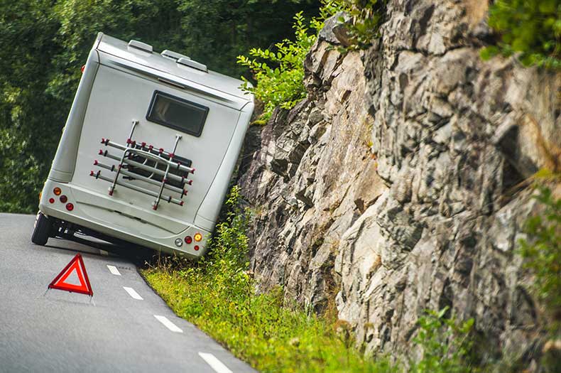 Caravan parked at the side of the road with a warning triangle behind it